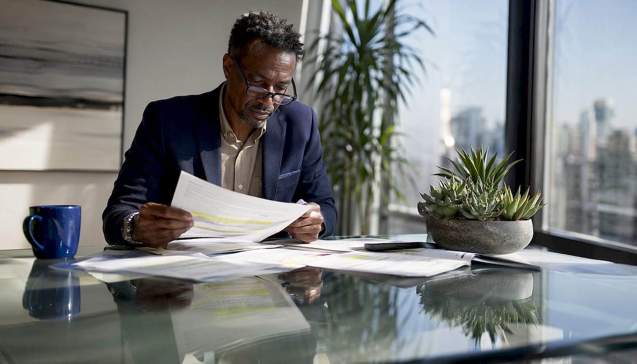 1784099491870_Real-estate-developer-reviewing-loan-offers-at-desk-1 Real estate developer reviewing loan offers at desk