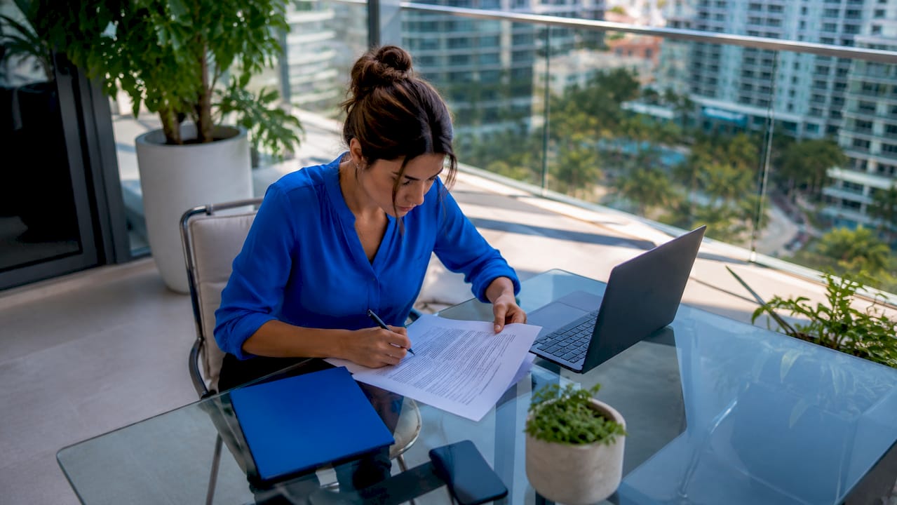 1784176411900_Real-estate-investor-reviewing-loan-documents-at-desk Real estate investor reviewing loan documents at desk
