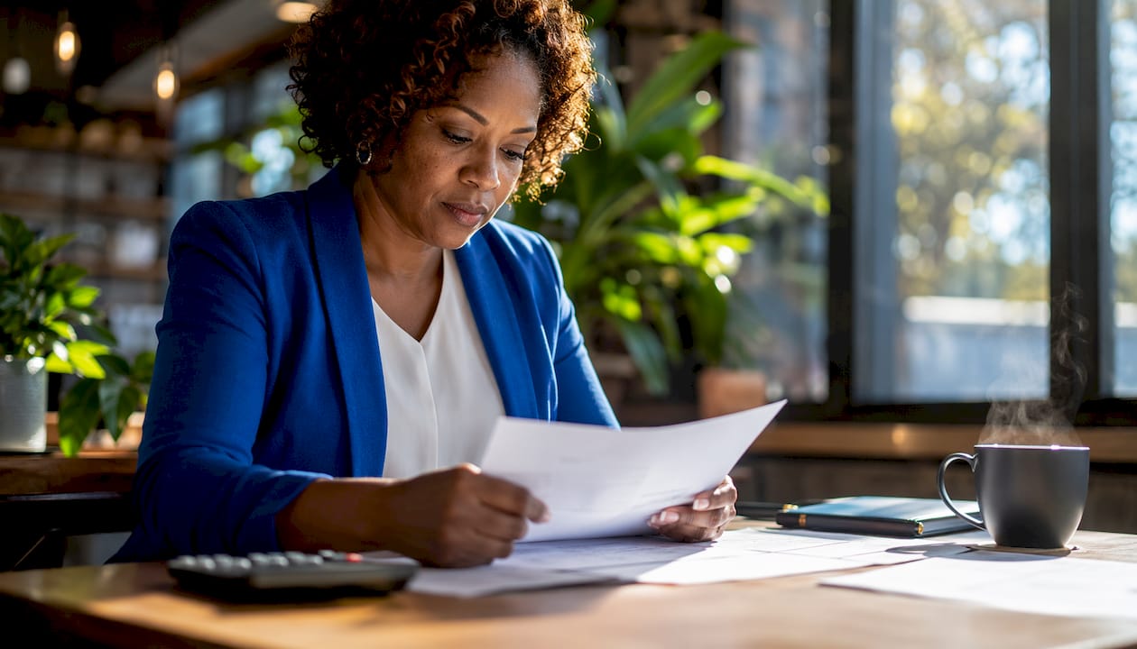 1784355905615_Woman-reviewing-real-estate-loan-documents Woman reviewing real estate loan documents