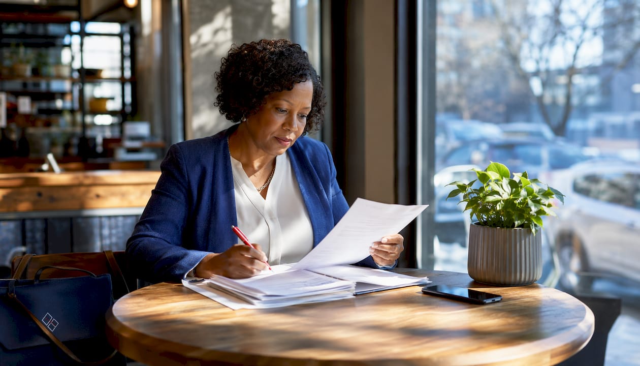 1784698895890_Lender-reviewing-construction-loan-documents-in-office Lender reviewing construction loan documents in office