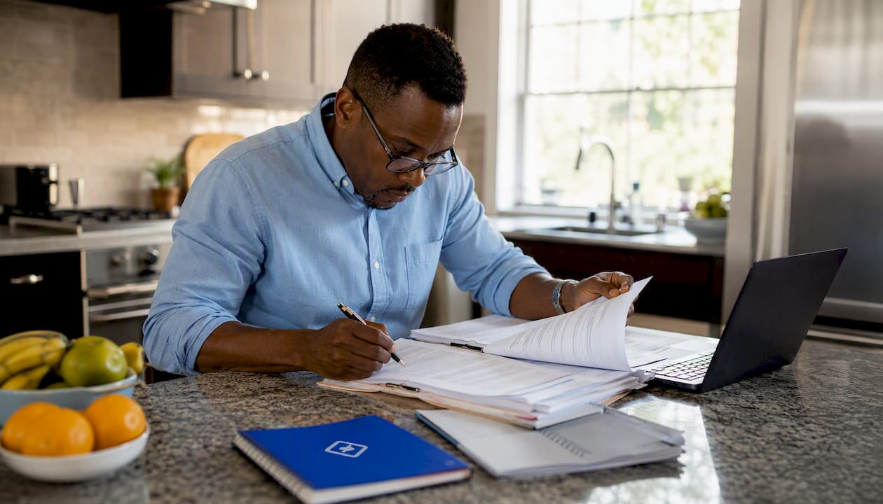 1785730698144_Investor-reviewing-loan-documents-at-home-office Investor reviewing loan documents at home office