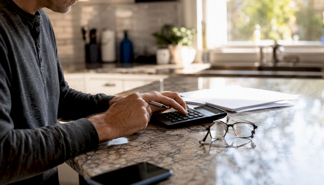 1786844033131_Hands-calculating-mortgage-points-with-documents Hands calculating mortgage points with documents
