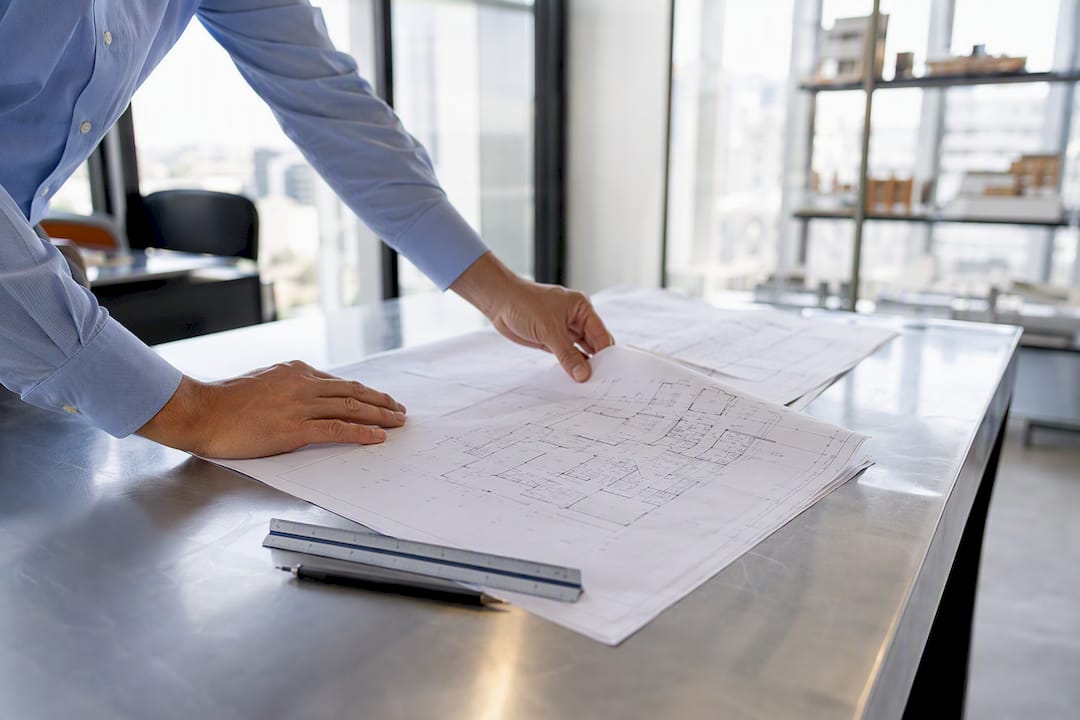 Hands reviewing blueprints on table